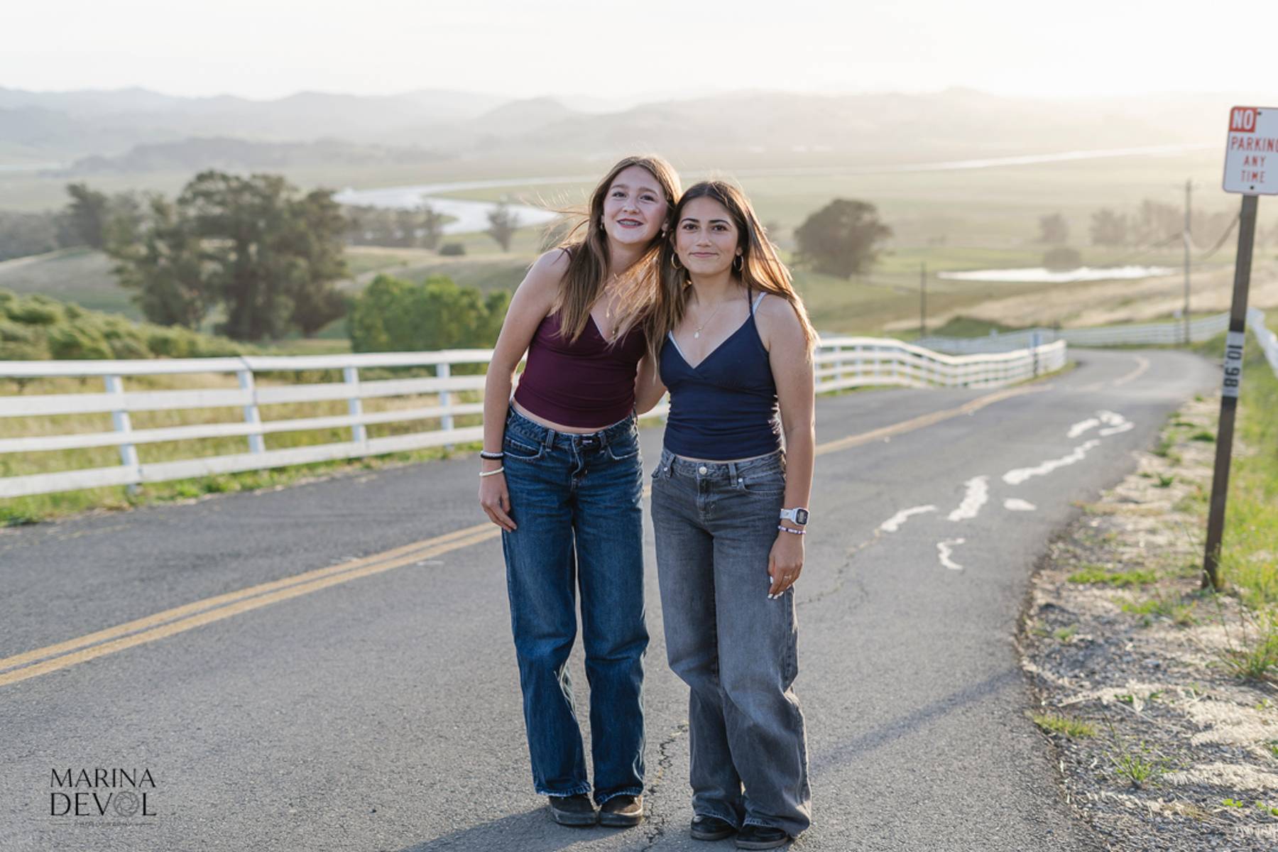 Two friends standing together with a valley view behind them