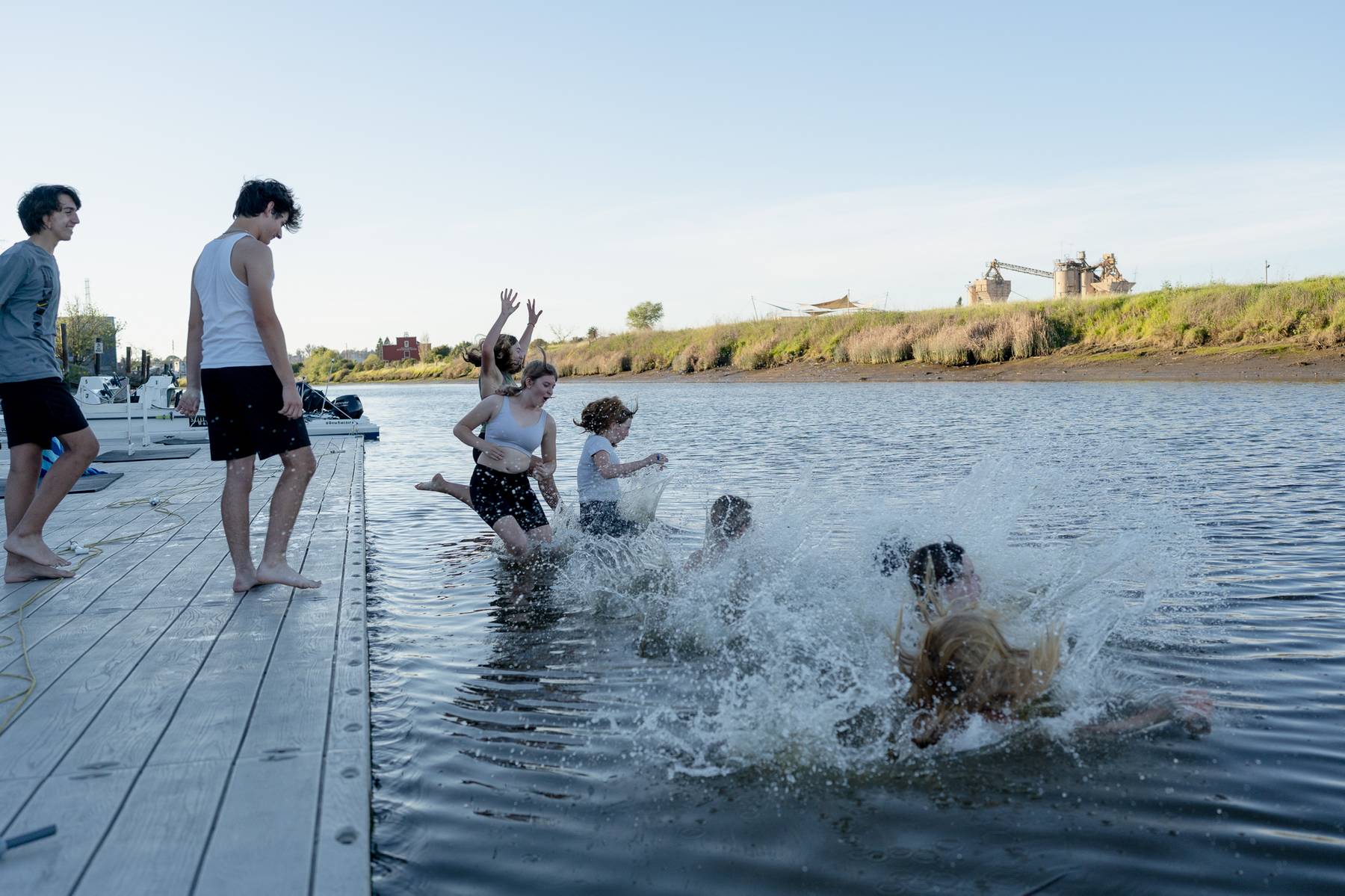 Teammates splashing into the river