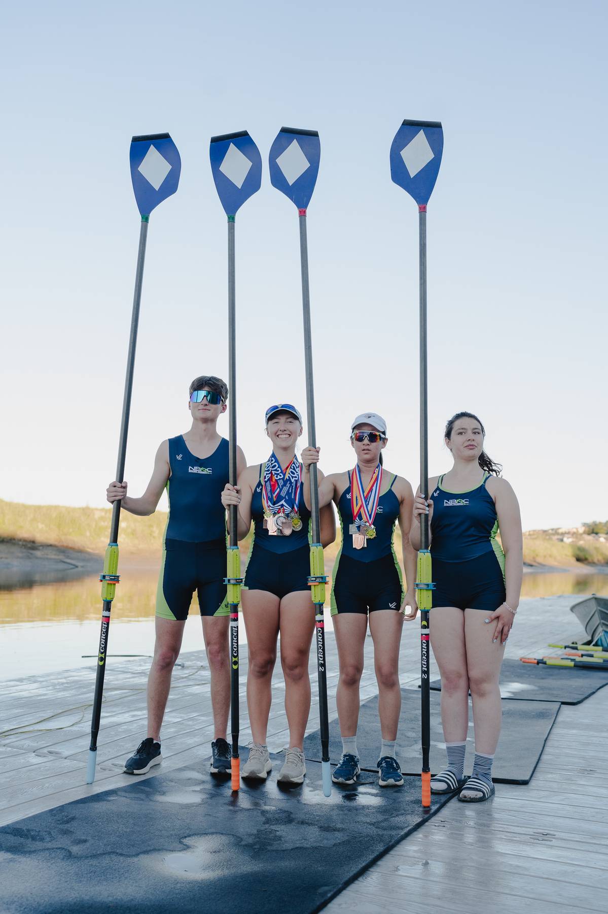 Rowing team portrait with oars raised
